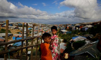 Rohingya children standing next to a bamboo fence