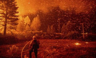 Photo of embers flying around a firefighter
