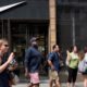 Photo of people passing in front of a Nike store in New York