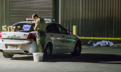 Photo of Kern County sheriff's deputy stands near an area where a shooting victim lies