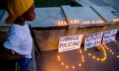 Photo of Solomon Grayson, 6, stands on a ledge next to a memorial