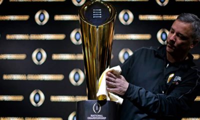Photo of Charley Green buffing the NCAA college football championship trophy