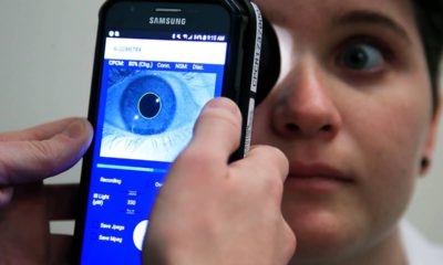 Photo of Clinical Research Assistant Kevin Jackson using AlgometRx Platform Technology on Sarah Taylor's eyes to measure her degree of pain