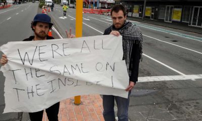 Photo of Linwood mosque shooting survivor Elliot Dawson, right, and a friend Shay Kenny holding a sign at an intersection