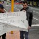 Photo of Linwood mosque shooting survivor Elliot Dawson, right, and a friend Shay Kenny holding a sign at an intersection