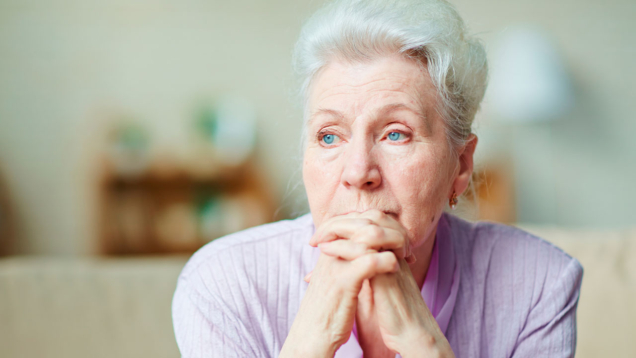 Older woman gazes off into the distance.