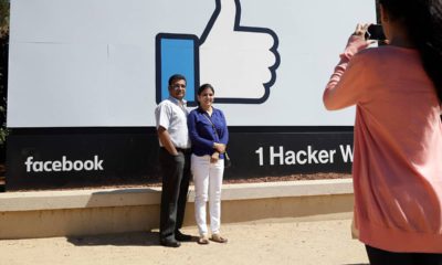 Photo of visitors taking pictures in front of the Facebook logo