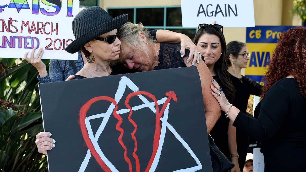 Leslie Gollub, left, and Gretchen Gordon hug at a vigil held to support the victims of the Chabad of Poway synagogue