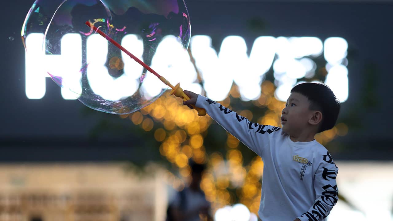Photo of a child playing with bubbles near the Huawei logo
