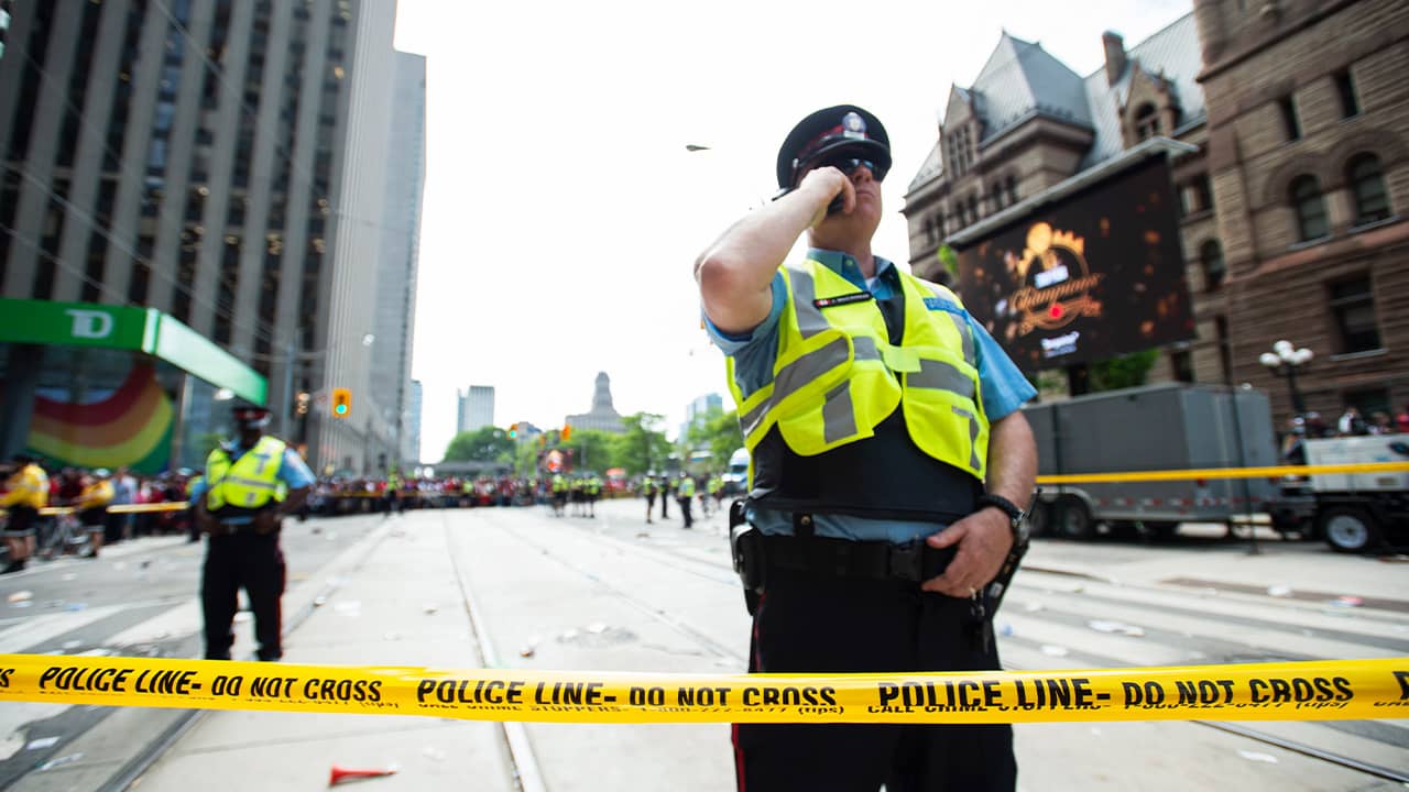 Photo of Toronto police securing the scene after shots were fired during the Raptors parade