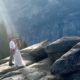 Photo of a couple at Yosemite's Glacier Point bathed in a ray of sunlight