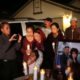 Photo of the wife and young daughter of shooting victim Kou Xiong standing among a crowd during a candle light vigil
