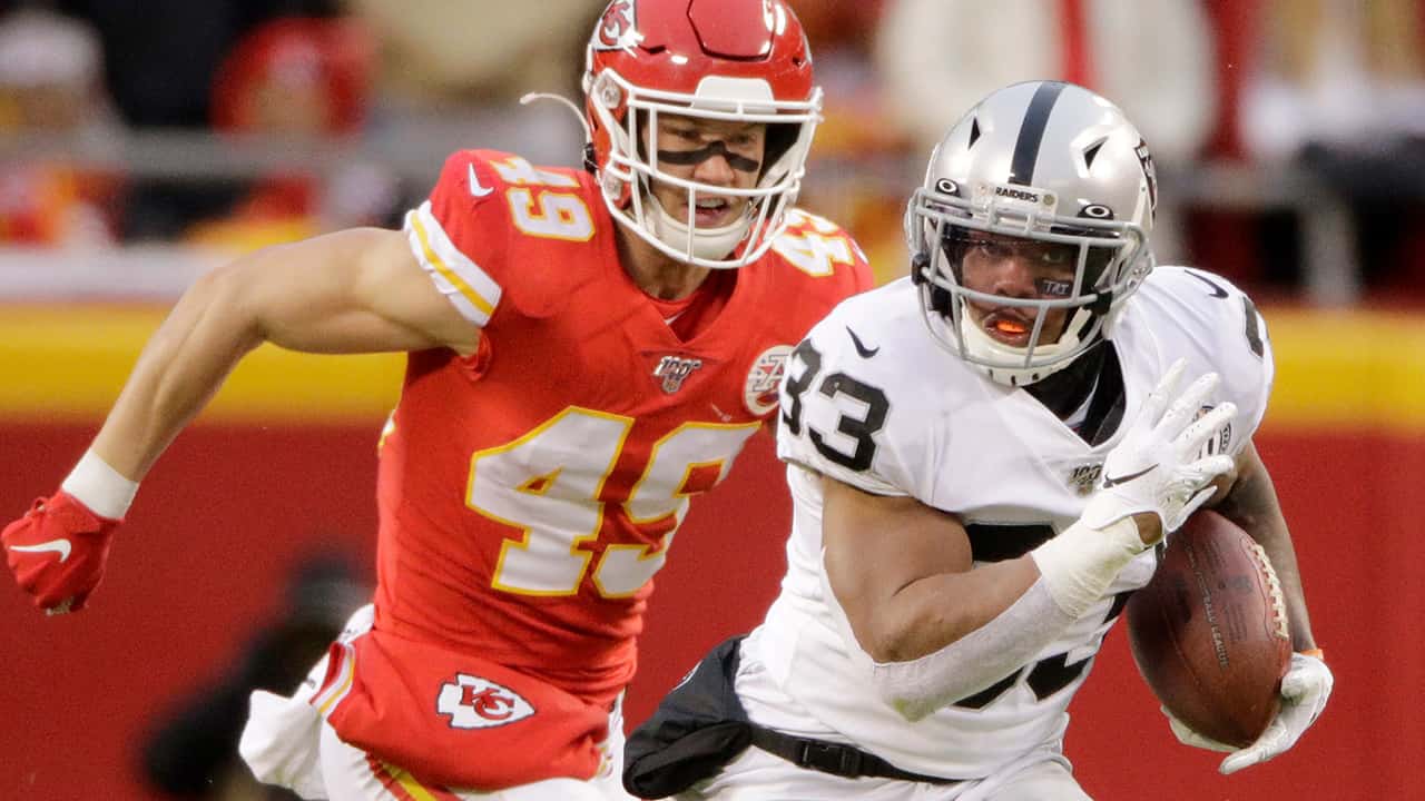 Photo of Oakland Raiders running back DeAndré Washington running away from Kansas City Chiefs safety Daniel Sorensen
