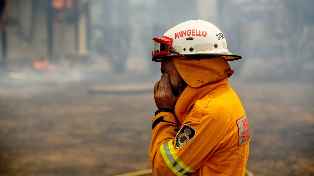 Photo of a firefighter covering his face