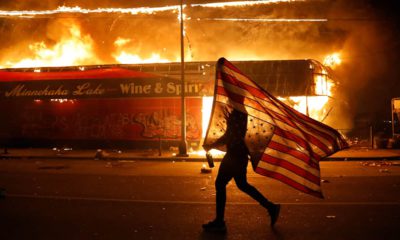 Photo of a protester carrying a flag upside down