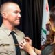 Photo of Deputy Nicholas Dreyfus receiving his badge from his wife